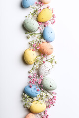 Easter quail eggs and springtime flowers over white background. Spring holidays concept with copy space. Top view - 580593223