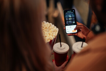 Couple using mobile app for booking movie tickets.