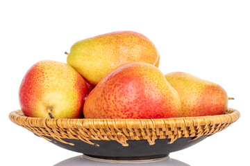 Several yellow-red pears on a ceramic plate, close-up, on a white background.