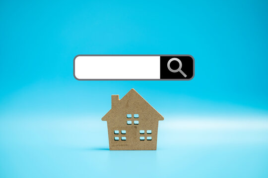 Small wooden home on blue background, new home concept.