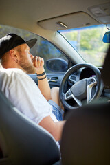 Man with beard is driving car, driver stuck in traffic jam
