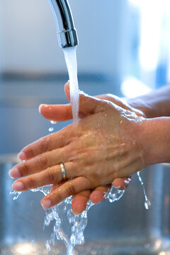 Female is washing her hands under the water tap
