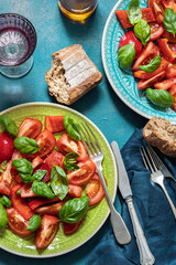 Tomato, bell pepper and basil Salad. Healthy mediterranean food. Laid appetizing table. Top view.