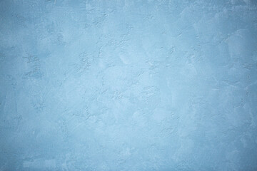 Blue background of decorative plaster with abstract spots. Unusual texture of this wall with beautiful patterns, creative surface background. Finishing coating for building cladding.