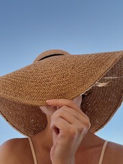Young pretty woman hide face with straw hat. Summer holidays vacation concept. Minimal fashion...