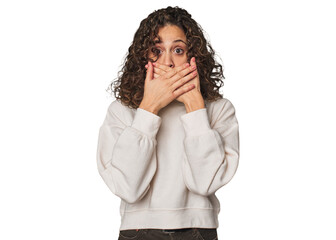 Radiant young woman with stunning curls shocked covering mouth with hands.