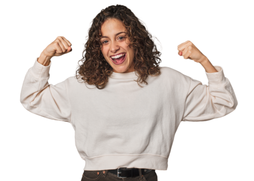 Radiant young woman with stunning curls showing strength gesture with arms, symbol of feminine power