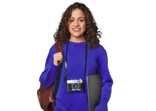 Joyful digital nomad with vintage camera and laptop.