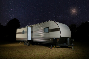 Bright star shining over an RV on a clear night