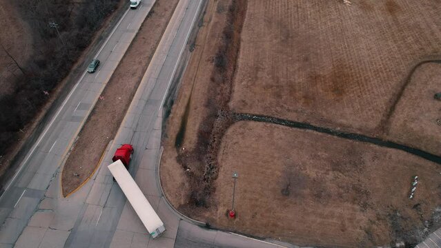 red semi tractor with white reefer-dryvan trailer doing right turn. Aerial USA 4k