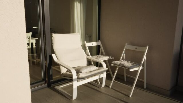 Revealing some chairs and armchair in a sunny corner of the terrace of a house.