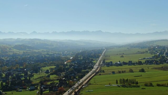 Scenic view on Zakopianka highway and majestic Tatra mountains hidden in mist on autumn day