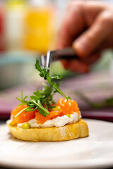 man chef hand cooking Bruschetta with salmon and cream cheese on restaurant kitchen