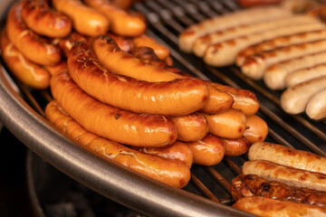 Close-up of German sausages being grilled on a coal fire. Selective focus.