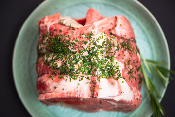 large piece of raw pork with spices for roasting in the oven