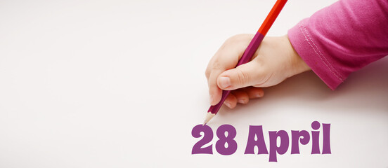 A child's hand writes 28 april in a lilac pencil. Banner with copy space