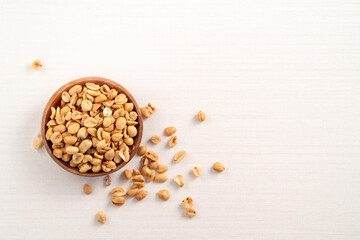 Spicy flavored peanut kernel in a bowl on white table background.