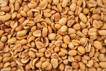 Spicy flavored peanut kernel spilling on white table background.