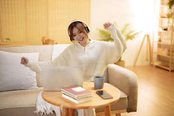 Young asian woman with headphones relaxing at home. listening to music