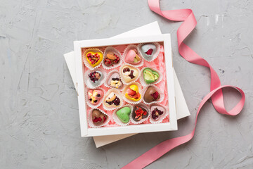 Holiday composition: sweet candy, with gift boxes with bow and chocolate hearts, photo template,...