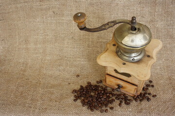 Rustikale Kaffeemühle -Vintage- auf Leinen mit Kaffeebohnen