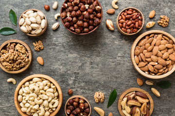 mixed nuts in wooden bowl. Mix of various nuts on colored background. pistachios, cashews, walnuts, hazelnuts, peanuts and brazil nuts