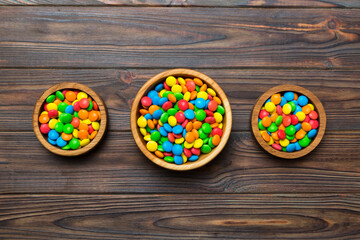 different colored round candy in bowl and jars. Top view of large variety sweets and candies with copy space