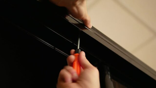 Man's hand assembles a closet with a screwdriver close-up