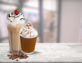 Iced latte with whipped cream and sauce on desk
