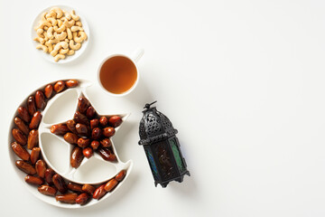 Holy month of Ramadan concept. Ramadan lantern, dates, nuts, food on white table.