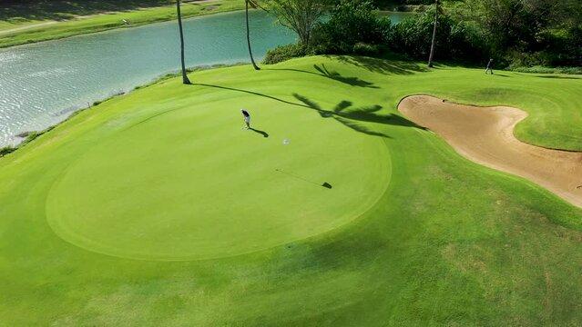 Golfer on putting green misses the shot-Aerial shot 4K