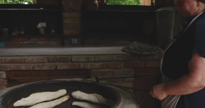 A Woman Baker With Turne Baking A Traditional Georgian Shotis Puri Or Shoti. Tilt-down