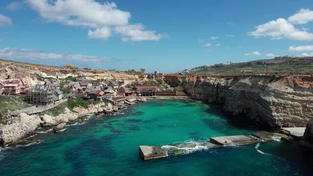 Drone View Over Popeye Village Theme Park In Malta With Rocky Shoreline And Turquoise Water