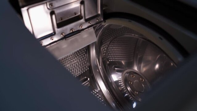The camera flies into a top-loading washing machine