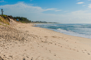 Fototapeta na wymiar Sandy beach and Atlantic ocean with waves in Floripa. Morro das Pedras beach in Florianopolis