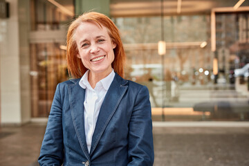 Fototapeta premium Successful middle-aged businesswoman smiling in front of luxury office.
