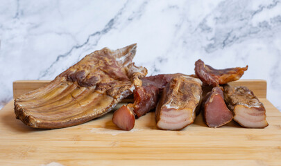 Dried pork meat smoked on traditional way on wooden table with copy space.