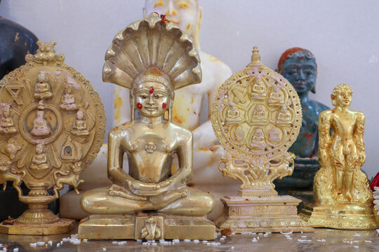 A Close up picture of Lord Parashwanath Tirthankara statue in gold metal at a Jain pilgrimage in Karnataka, India.
