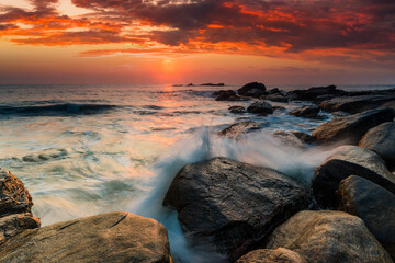 Fototapeta na wymiar Sunset on the rocky shore of tropical sea