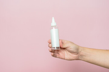 Woman hand holding cosmetic bottle. Cosmetic product branding mockup. Daily skincare and body care routine.