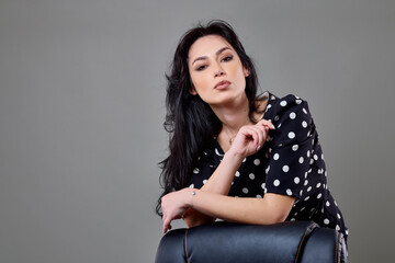 a beautiful brunette business woman in different poses on a gray background.