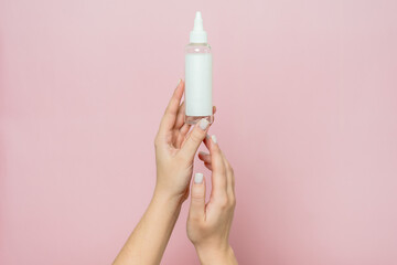 Cosmetic bottle in woman's hands. Cosmetic product branding mockup. Daily skincare and body care routine.