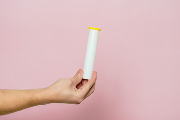 Hand holding bottle for pills, effervescent tablets or vitamin