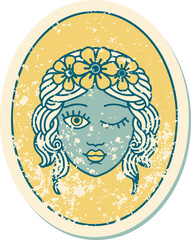 distressed sticker tattoo style icon of a maiden with crown of flowers winking