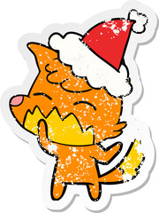 distressed sticker cartoon of a fox wearing santa hat
