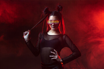Portrait of beautiful cyber model woman posing wearing led glasses on head with neon light in a...