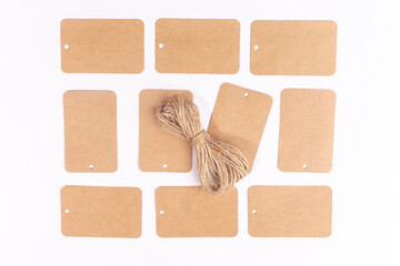 Brown gift cardboard patterned tags and rope ribbon on white background