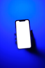 Phone in hand in neon blue fog