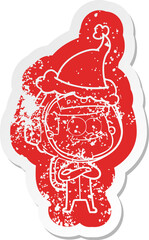 happy astronaut cartoon distressed sticker of a wearing santa hat