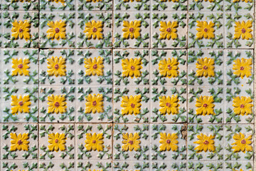 Fragment of building wall with yellow floral ceramic wall tiles Azulejo Abstract decorative...